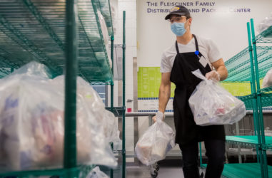 Person prepares meals for distribution by the Metropolitan Area Neighborhood Nutrition Alliance of Philadelphia